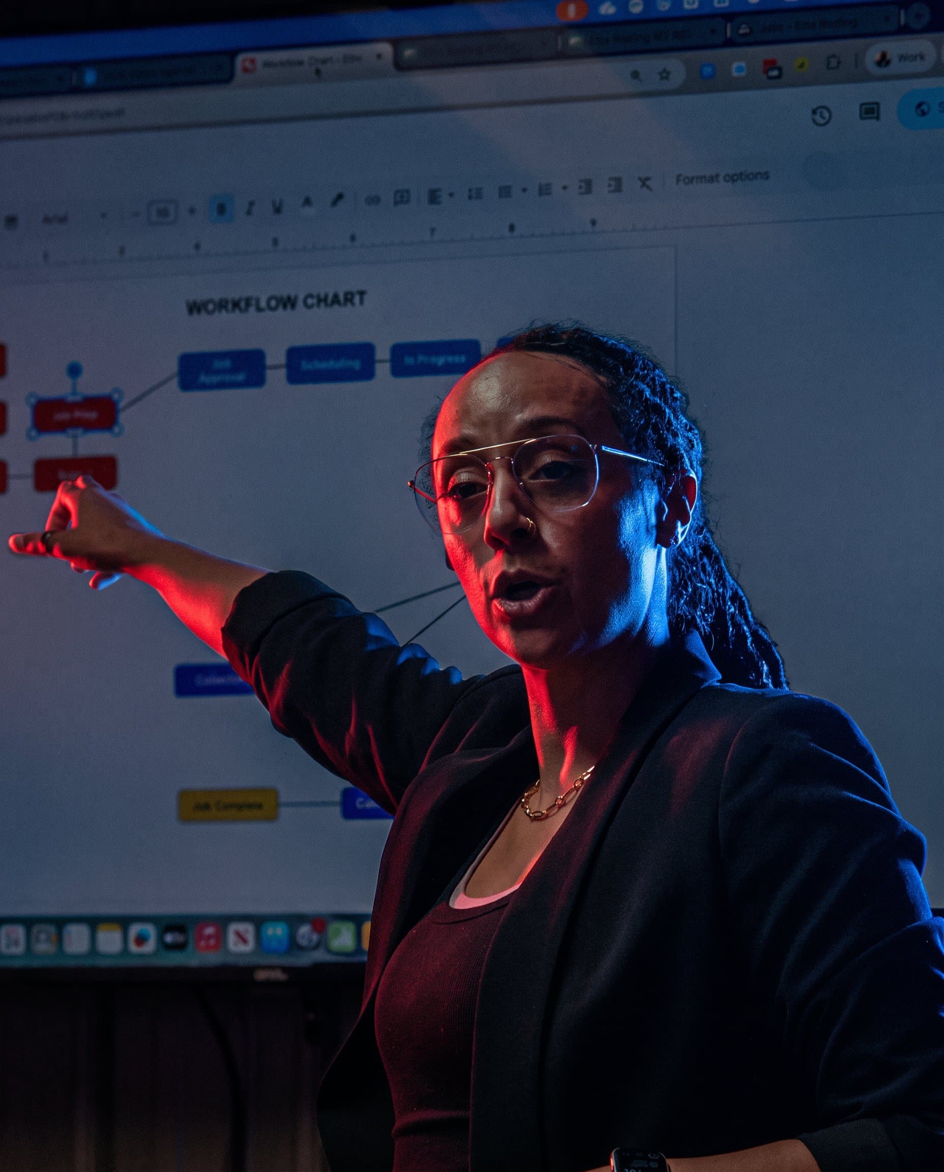 A Roofing Academy coach walks a member team through their workflow chart on the screen.
